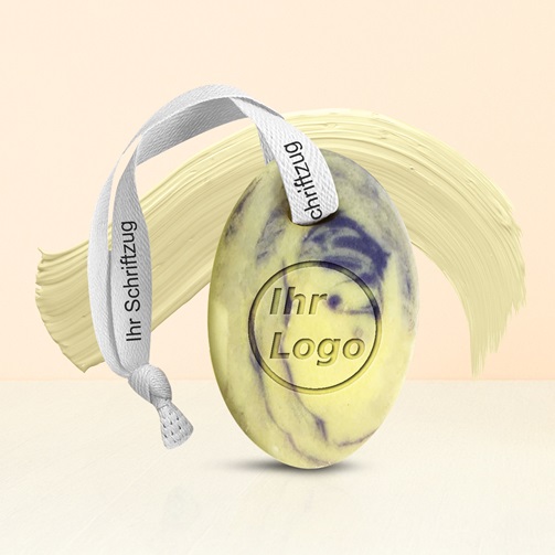 „Oval geformte, marmorierte Handseife mit Ihrem Logo und Stoffband, vor hellem Hintergrund.